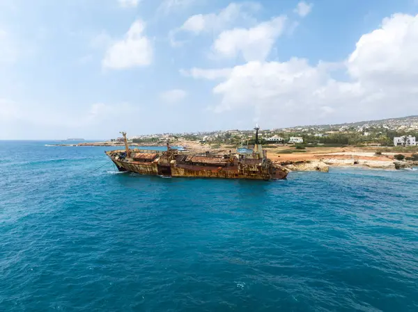 Edro III 'ün enkazı, arka planda beyaz binalar ve yeşilliklerle çevrili, Kıbrıs' ın Paphos kentinin kayalık kıyı şeridi yakınlarında yer alıyor..