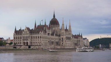 Budapeşte 'deki Macar Parlamento Binası Tuna Nehri üzerinde süzülen beyaz bir tekne ile hafif bulutlu bir gökyüzüne doğru yola çıktı..