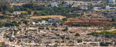 Kıbrıs 'taki Ayia Napa Heykel Parkı' nda yeşil evler, tarlalar ve dolambaçlı yollarla çevrili kayalık bir arazide beyaz taş heykeller yer alıyor..