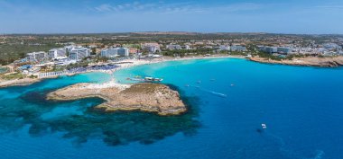 Turkuaz sular, güneşli kumlu kıyılar, lüks tatil beldeleri ve kayalık bir yarımada Ayia Napa 'nın Kıbrıs' taki kıyı şeridinin bu hava manzarasını tanımlıyor.