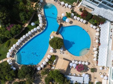 Kıbrıs Rum Kesimi 'nin Ayia Napa kentindeki lüks tatil beldesinde üç bölüm, küçük bir köprü, beyaz şemsiyeler, güneş panzeleri ve bereketli tropik yeşillikler yer alıyor..