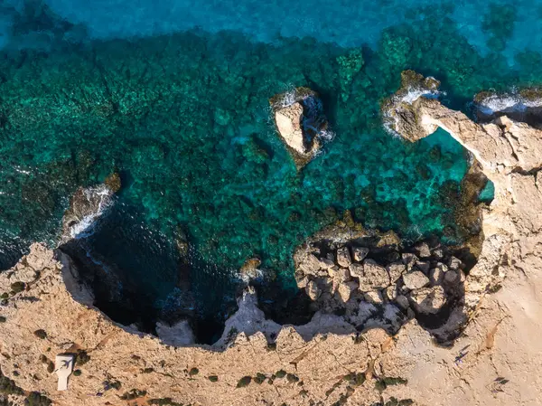 Kıbrıs Rum Kesimi 'nin Ayia Napa kentinin hava görüntüleri turkuaz suları, doğal bir kaya kemeri, engebeli kireçtaşı oluşumları ve su altı kayalarını gösteriyor..