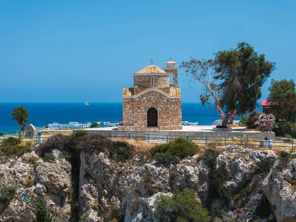Kıbrıs Rum Kesimi 'nin Ayia Napa kentindeki Aziz Elias Kilisesi, kayalık bir tepenin üzerinde altın taş duvarlar, bir kubbe, seyrek bir bitki örtüsü ve kıyı şeridi manzarası ile oturmaktadır..