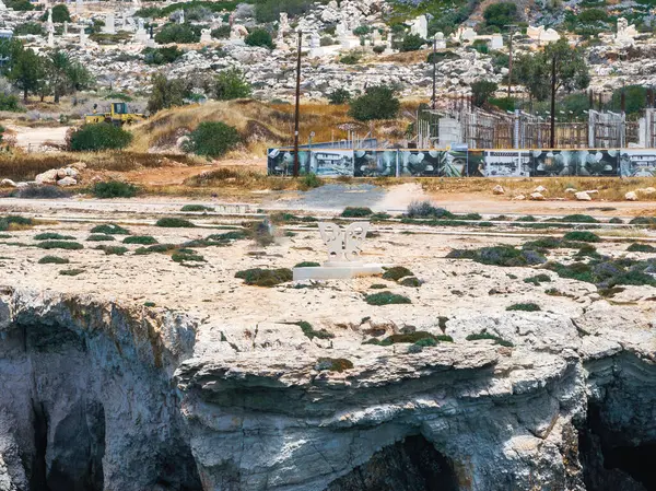Nadir bitki örtüsüne sahip engebeli uçurumlar, beyaz bir aşk heykeli, çitlerle kaplı bir alan, duvar resimleri ve Kıbrıs Rum Kesimi 'nin Ayia Napa kentindeki mezar taşları..