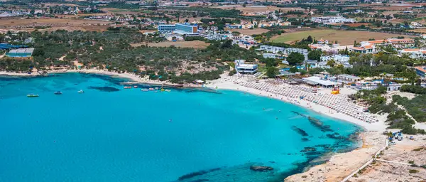 Kıbrıs Rum Kesimi 'nin Ayia Napa kentindeki Nissi Sahili' nin hava manzarasında turkuaz sular, güneşli kumlu kıyılar, tatil beldeleri ve deniz yüzücüleri görülüyor..