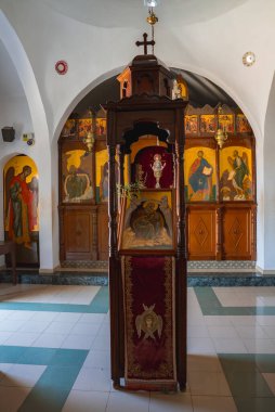 Kıbrıs 'taki küçük bir Ortodoks St. Elias Kilisesi' nin içinde işlemeli kırmızı kadife kumaş ve altın çerçeveli bir ikonostaz içeren ahşap bir simge standı bulunuyor..