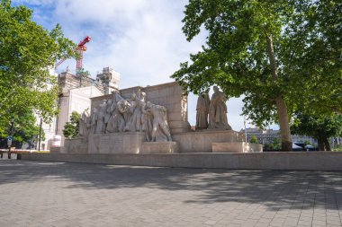 Ağaçlarla, inşaat alanlarıyla ve Budapeşte 'de açık mavi gökyüzüyle çevrili, asfalt bir meydandaki dinamik insan heykelleriyle ünlü taş anıt..