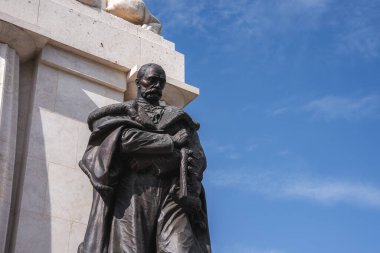 Tisza Istvan Anıtı. Üzerinde bir aslan heykeli bulunan taş bir heykelin parçası olan tarihi bir figürün ayrıntılı bronz heykeli, açık mavi gökyüzüne karşı dizilmiş..