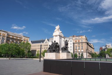Macaristan, Budapeşte 'de bronz heykelleri olan beyaz bir taş heykel. Süslü tarihi binalar, açık bir plaza ve açık mavi gökyüzü ile çevrili..