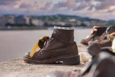 Macaristan 'ın Budapeşte kentindeki Danube Bank anıtının Shoes on the Tuna Bank' ta kurdele ve İbranice metin ile bronz ayakkabı heykeli.