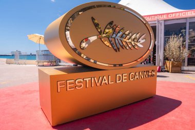Büyük Altın Palmiye d 'Or heykeli kırmızı halıda' Festival de Cannes 'metni, beyaz çadır, bitkiler, mavi gökyüzü, deniz ve Fransa' nın Cannes kentinde kenetlenmiş gemi.
