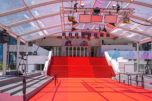 Fransa 'nın Cannes kentindeki Palais des Festivals' teki ikonik kırmızı halı ve merdiven, şeffaf bir tepe örtüsü, aydınlatma platformları ve festival markası görünür..
