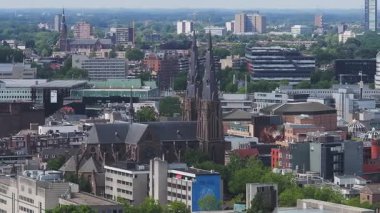 Eindhoven, Hollanda 'nın havadan görünüşü, St. Catherine Kilisesi' nin sergilenmesi, modern yüksek binalar, tarihi binalar, ve yavaş çekimde yeşillik.