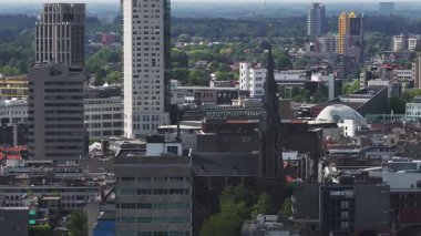 Hollanda 'nın Eindhoven şehrinin yavaş, engebeli bir havası. St. Catherine Kilisesi, Evoluon Kubbesi, modern binalar ve yeşil alanlar sergileniyor..