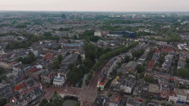 Hollanda 'nın Utrecht kentinin hava manzarası, kanalları, geleneksel Hollanda binalarını, mavi bir yapıyı ve kademeli olarak hareket eden yeşillikleri gösteriyor..