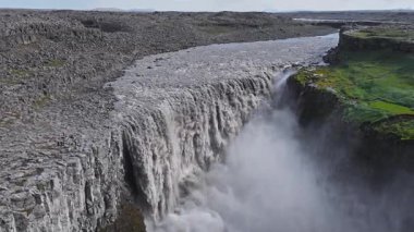 İzlanda 'daki Dettifoss şelalesi, sürekli dinamik su hareketleriyle kayalık arazi ve yosun kaplı uçurumlarla çevrili derin bir kanyona dalıyor..
