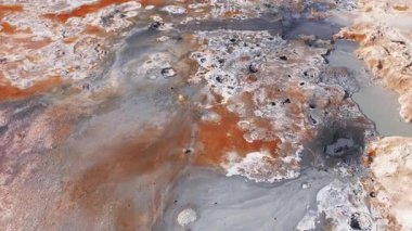 İzlanda 'nın Heverjeotermal bölgesinde canlı bir arazi, dumanı tüten fümeroller, kaynayan çamur havuzları ve patika ve yürüyüş yolları boyunca yürüyen ziyaretçiler yer almaktadır..