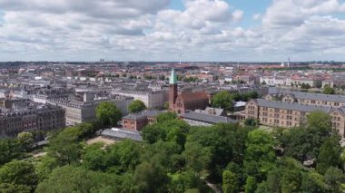 Kopenhag, Danimarka 'da hava temizliği, tarihi ve modern mimari, şehir parkları ve bulutlu gökyüzünün altında belirgin bir siluet sergileniyor..