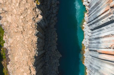 İzlanda 'daki Studlagil Kanyonu' nda etkileyici bazalt sütunlar ve canlı bir turkuaz nehir bulunur. Engebeli arazi ve ışık çarpıcı zıtlıklar yaratır..