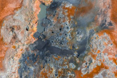 İzlanda 'da kaynayan çamur kapları, buharlı bacalar, mineral yatakları ve parlak renklerde saçılmış sütlü su havuzları içeren jeotermal manzaralar.