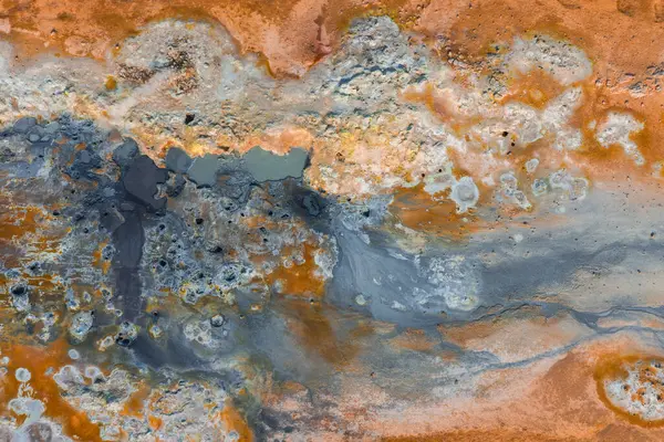 İzlanda 'da turuncu ve pas renginde toprak, buhar menfezleri, kaynayan çamur kapları ve havadan bakıldığında mineral yataklarının yer aldığı jeotermal alan..