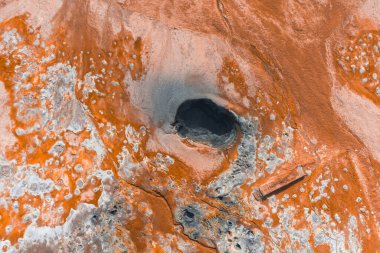 İzlanda 'da turuncu ve beyaz mineral yatakları, koyu bir havalandırma, çamur kapları, fümeroller ve ziyaretçiler için ahşap bir yürüyüş yolu bulunan jeotermal alan.