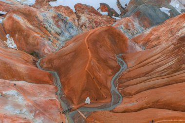 Canlı turuncu ve kırmızı rhyolite tepeleri buhar bacaları, kar bantları ve İzlanda 'nın Kerlingarfoll dağ sırasındaki ahşap bir patika..