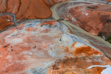 İzlanda 'daki Kerlingarfjoll' da turuncu ve kırmızı rhyolite dağları, buharlı bacalar, dolambaçlı bir nehir, ahşap yollar ve küçük ziyaretçi grupları yer almaktadır..