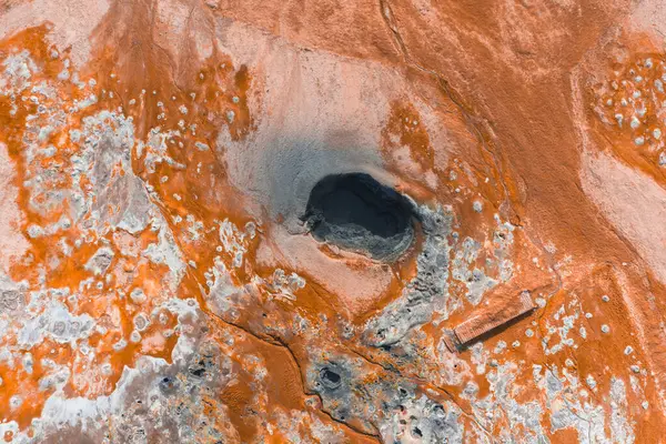 İzlanda 'da turuncu ve beyaz mineral yatakları, koyu bir havalandırma, çamur kapları, fümeroller ve ziyaretçiler için ahşap bir yürüyüş yolu bulunan jeotermal alan.