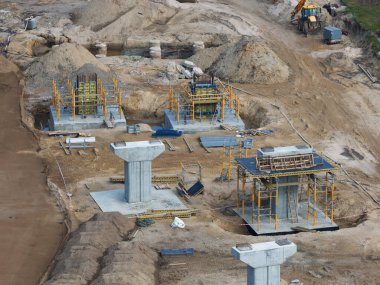 Riga 'dan Jelgava yoluna kadar inşaat alanında beton sütunlar, iskeleler, ağır makineler ve malzeme ve ekipman için organize alanlar var..