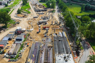 Riga 'dan Jelgava yoluna kadar geniş ölçekli yol inşaatı vinçler, kazıcılar, beton sütunlar ve Letonya' da yeşil alanlar yakınında kısmen tamamlanmış bir köprü..