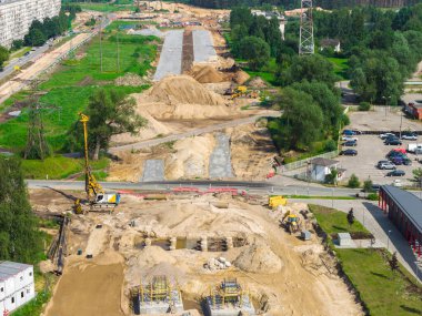 Riga 'dan Jelgava yoluna kadar büyük ölçekli yol inşaatı. Ağır makineler, kum, çakıl ve kısmen asfalt kaplı bir yol..