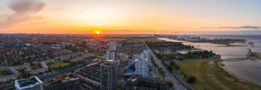 Kopenhag, Danimarka 'nın hava görüntüsü, günbatımında Amager Bakke fabrikası, açık deniz rüzgar türbinleri, su yolları ve modern ve geleneksel mimarinin karışımı..