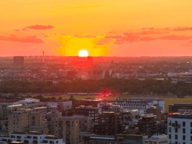 Kopenhag, Danimarka 'nın günbatımında modern binaların, yeşil alanların ve Amager Bakke atığının bulunduğu hava manzarası.