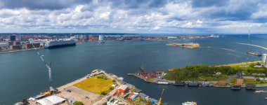 Danimarka, Kopenhag 'ın hava görüntüsü, limanda bir yolcu gemisi, enerji santrali, kentsel binalar ve yeşil alanlar Amager Bakke atıklarını gösteriyor..