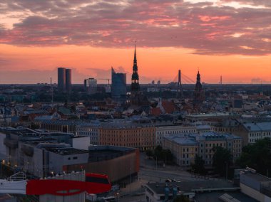 Riga, Letonya ufuk çizgisi gün batımında Aziz Peter Kilisesi kulesi, Riga TV Kulesi, Vansu Köprüsü ve tarihi ve modern mimarinin karışımı.