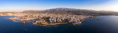 Chania, Girit 'in havadan görünüşü, beyaz ve pastel binalar, deniz feneri, Akdeniz ve Lefka Ori dağlarını gösteriyor..