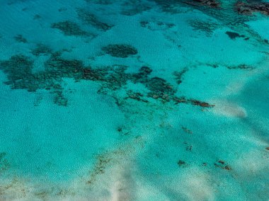 Girit 'teki Elafonisi Sahili' nin havadan görünüşü, turkuaz sular, kumlu alanlar, koyu deniz yamaçları, ışık ve gölge zıtlıkları sergileniyor.