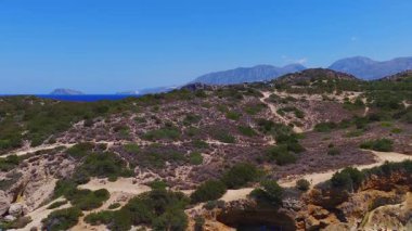 Girit 'teki Voulisma Sahili' nin havadan görünüşü turkuaz suları, engebeli araziyi, beyaz binaları ve pürüzsüz hareketli dağlık zemini gösteriyor..