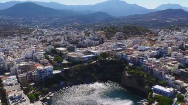 Agios Nikolaos, Girit 'in havadan görünüşü, beyaz ve pastel binaları, yeşillikleri, yuvarlanan tepeleri ve yavaş yavaş hareket eden dağları gösteriyor..