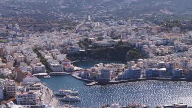 Girit 'teki Agios Nikolaos' un yavaş hareket eden havası, Akdeniz binalarını, canlı bir marinayı, mavi bir körfezi ve yuvarlanan tepeleri gösteriyor..