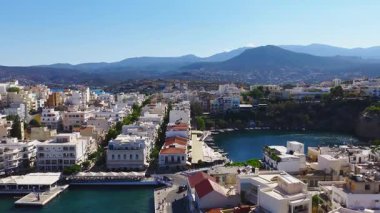 Girit 'teki Agios Nikolaos' un havadan görünüşü beyazlatılmış binaları, bir marinayı, turkuaz suları ve geniş bir hareketle engebeli dağları gösteriyor..