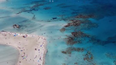 Yunanistan 'ın Girit kentindeki Elafonisi Sahili' nin havadan görünüşü, pembe kum, turkuaz sular, dağınık bitki örtüsü ve kıyı şeridi boyunca uzanan küçük botları gösteriyor..