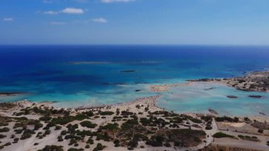 Yunanistan 'ın Girit kentindeki Elafonisi Sahili' nin havadan görünüşü, pembe kum, turkuaz sular, küçük adalar ve kıyı şeridi üzerinde geniş çaplı bir hareket gösteriyor..