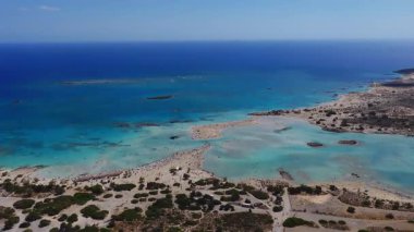 Girit 'teki Elafonisi Sahili' nin havadan görünüşü turkuaz suları, kayalık adalar ve düz ileri hareket eden karmaşık kumsallar sergileniyor..
