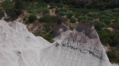 Girit 'teki beyaz Kamolithi dağlarının havadan görünüşü aşınmış oluşumlar, bir tarladaki altın saman balyaları ve manzaradaki yeşillik bölgeleri..