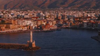 Yunanistan 'ın Girit kentindeki Chania şehrinin havacılık panosu, gün batımında Venedik Limanı, deniz feneri, tarihi binalar ve dağlar sergileniyor..