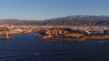 Yunanistan 'ın Girit kentindeki Chania kasabasının hava görüntüsü Venedik limanı, deniz feneri ve gün batımında Ege Denizi' ni çevreleyen geniş çaplı bir hareketle.