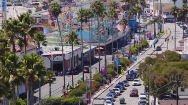 Santa Cruz, California 'nın hava manzarası, canlı tahta yolu, Dev Ayı Lunaparkı hız treni, hareketli sokaklar, palmiye ağaçları ve kıyı şeridini gösteriyor..