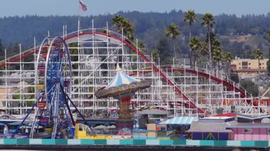 Santa Cruz, California 'nın havadan görünüşü, dev hız trenini, yüksek palmiye ağaçlarını ve dinamik hareketli orman yamacını vurguluyor..